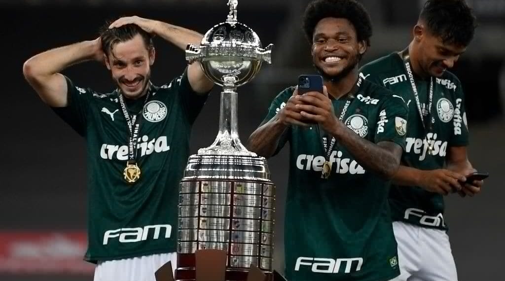 RIO DE JANEIRO, BRAZIL - JANUARY 30: Matias Vina (L) and teammate Luiz Adriano of Palmeiras look at the trophy after winning  the final of Copa CONMEBOL Libertadores 2020 between Palmeiras and Santos at Maracanã Stadium on January 30, 2021 in Rio de Janeiro, Brazil. (Photo by Mauro Pimentel – Pool/Getty Images)
