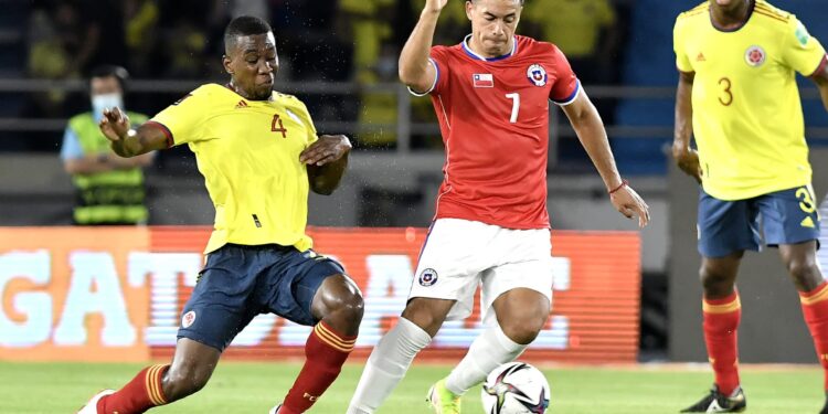 BARRANQUILLA, COLOMBIA - SEPTEMBER 09: Carlos Cuesta of Colombia competes for the ball with Iván Morales of Chile during a match between Colombia and Chile as part of South American Qualifiers for Qatar 2022 at Estadio Metropolitano on September 09, 2021 in Barranquilla, Colombia. (Photo by Gabriel Aponte/Getty Images)