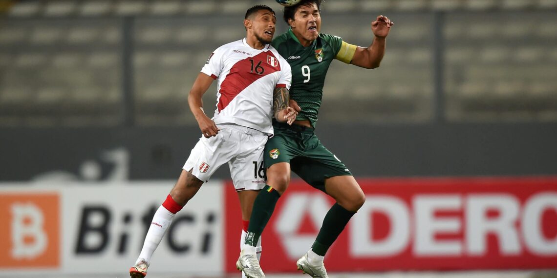 LIMA, PERU - NOVEMBER 11: Christofer Gonzáles of Peru jumps for the ball with Marcelo Moreno Martins of Bolivia during a match between Peru and Bolivia as part of FIFA World Cup Qatar 2022 Qualifiers at Estadio Nacional de Lima on November 11, 2021 in Lima, Peru. (Photo by Ernesto Benavides - Pool/Getty Images)