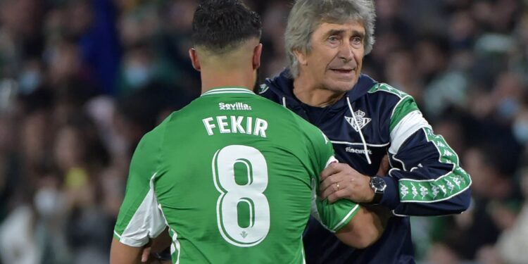 Real Betis' French midfielder Nabil Fekir (L) is congratulated by Real Betis' Chilean coach Manuel Pellegrini after scoring a goal during the Spanish league football match between Real Betis and Real Sociedad at the Benito Villamarin stadium in Seville on December 12, 2021. (Photo by CRISTINA QUICLER / AFP) (Photo by CRISTINA QUICLER/AFP via Getty Images)