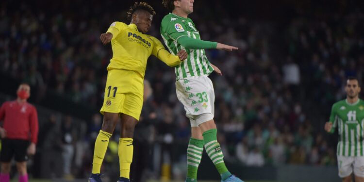 Villarreal's Nigerian midfielder Samuel Chukwueze (L) and Real Betis' Spanish defender Juan Miranda jump for the ball during the Spanish league football match between Real Betis and Villarreal CF at the Benito Villamarin stadium in Seville on February 6, 2022. (Photo by CRISTINA QUICLER / AFP) (Photo by CRISTINA QUICLER/AFP via Getty Images)