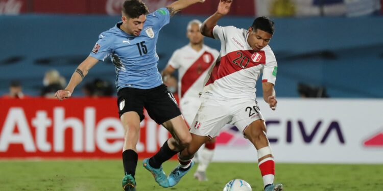 Uruguay's Federico Valverde (L) and Peru's Edison Flores (R) vie for the ball during their South American qualification football match for the FIFA World Cup Qatar 2022 at the Centenario Stadium in Montevideo on March 24, 2022. (Photo by Raul MARTINEZ / POOL / AFP) (Photo by RAUL MARTINEZ/POOL/AFP via Getty Images)
