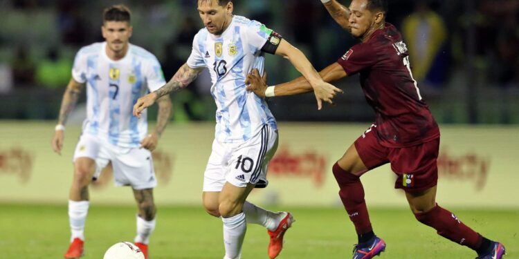 Argentina's Lionel Messi (L) is marked by Venezuela's Jose Martinez during their South American qualification football match for the FIFA World Cup Qatar 2022 between Venezuela and Argentina at the UCV Olympic Stadium in Caracas on September 2, 2021. (Photo by Edilzon Gamez / POOL / AFP) (Photo by EDILZON GAMEZ/POOL/AFP via Getty Images)
