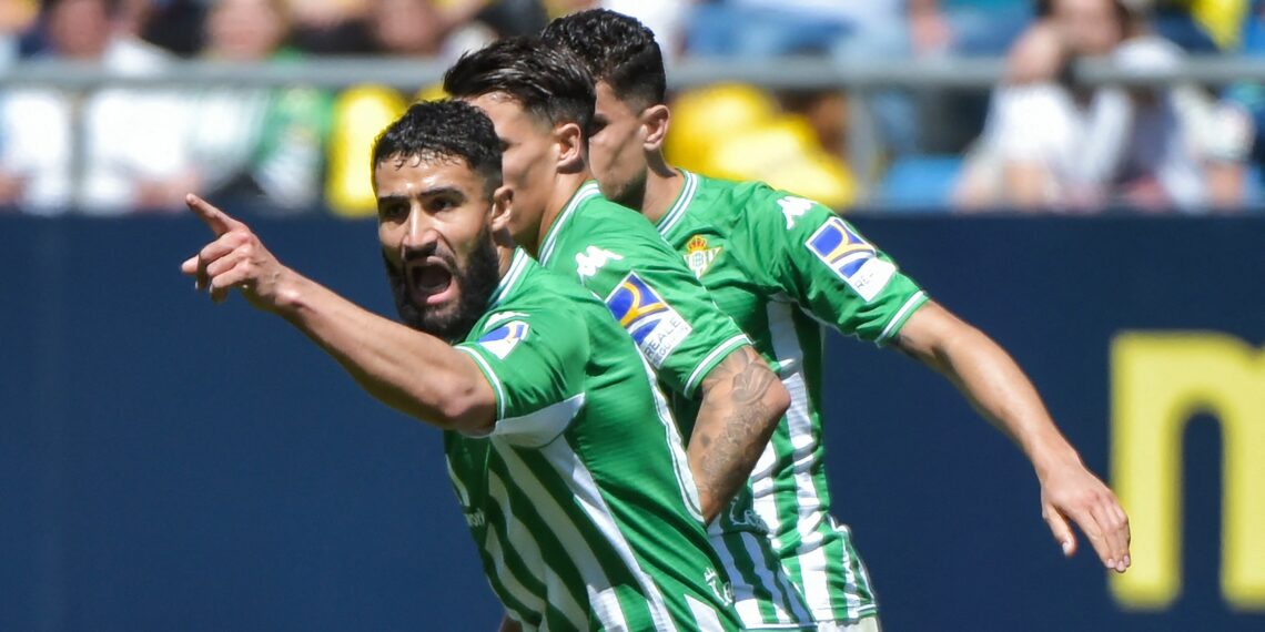 Real Betis' Spanish midfielder Cristian Tello (C) celebrates with Real Betis' French midfielder Nabil Fekir (L) after scoring his team's first goal during the Spanish league football match between Cadiz CF and Real Betis at the Nuevo Mirandilla stadium in Cadiz on April 9, 2022. (Photo by CRISTINA QUICLER / AFP) (Photo by CRISTINA QUICLER/AFP via Getty Images)