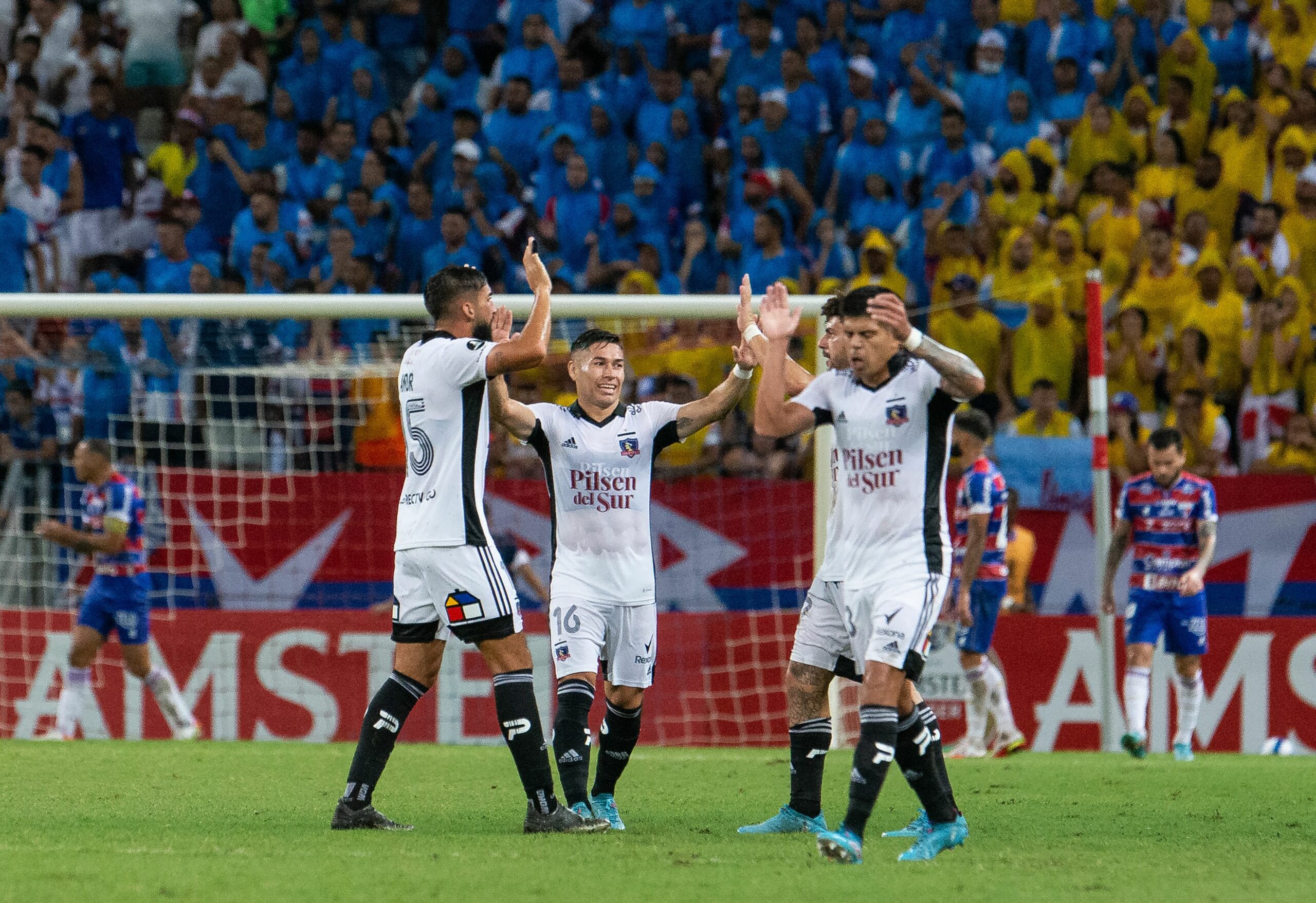 (L t R) Chile's Colo Colo Argentine Emiliano Amor (L), Oscar Opazo and Esteban Pavez  celebrate a goal against Brazil's Fortaleza during their Copa Libertadores group stage first leg football match between  at the Arena Castelao stadium, in Fortaleza, Brazil, on April 7, 2022. (Photo by Thiago Gadelha / AFP) (Photo by THIAGO GADELHA/AFP via Getty Images)