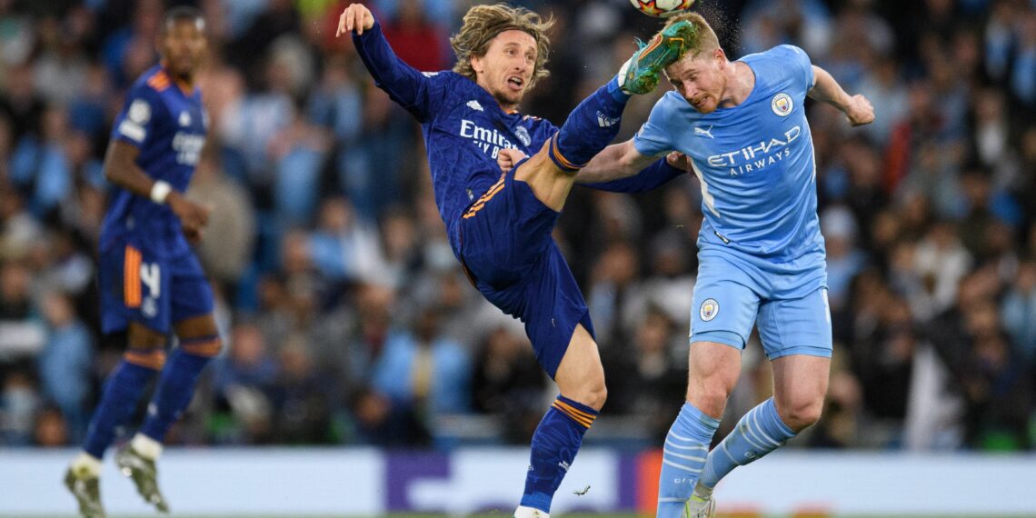 Real Madrid's Croatian midfielder Luka Modric (L) fights for the ball with Manchester City's Belgian midfielder Kevin De Bruyne  during the UEFA Champions League semi-final first leg football match between Manchester City and Real Madrid, at the Etihad Stadium, in Manchester, on April 26, 2022. (Photo by OLI SCARFF / AFP) (Photo by OLI SCARFF/AFP via Getty Images)